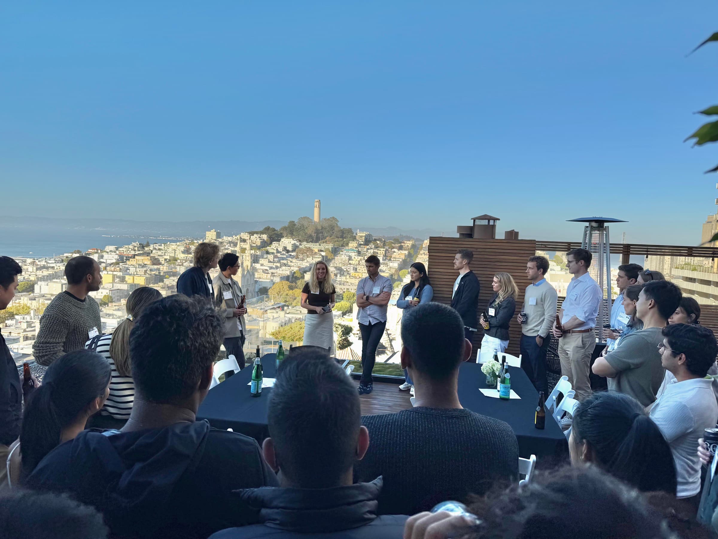 Fellows gathered on a San Francisco rooftop overlooking the city
